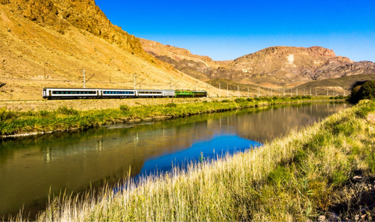 Landscape with train driving on the river bank in Iran