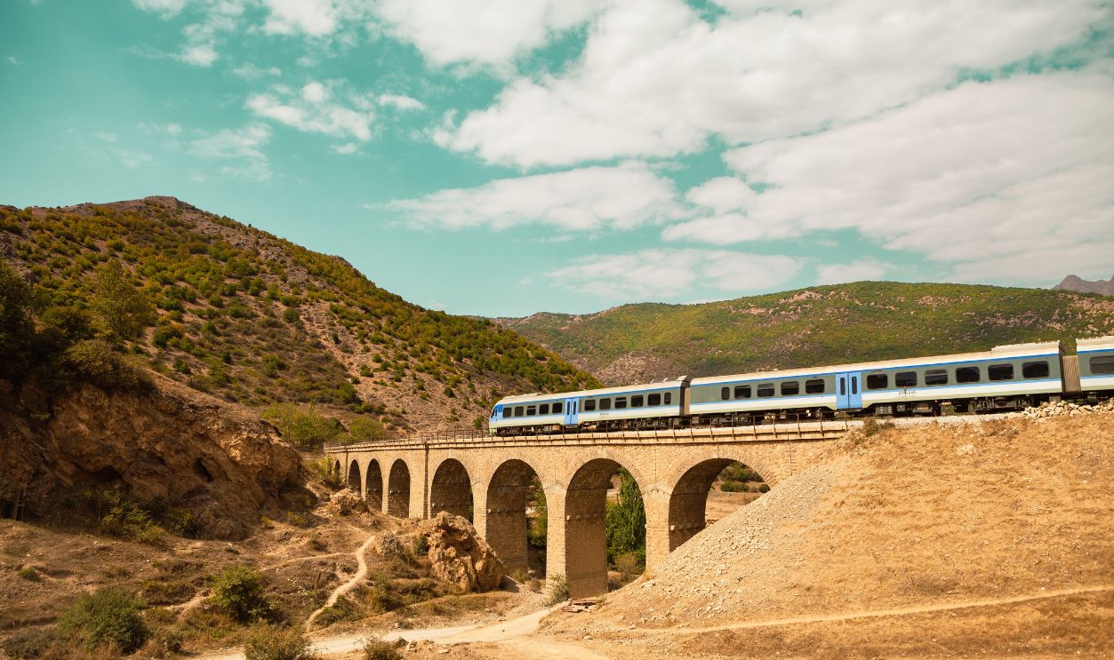 A train is passing over a bridge in the mountainous region of Iran