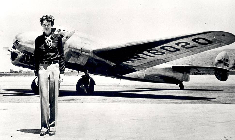 Amelia Earhart standing in front of the Lockheed Electra