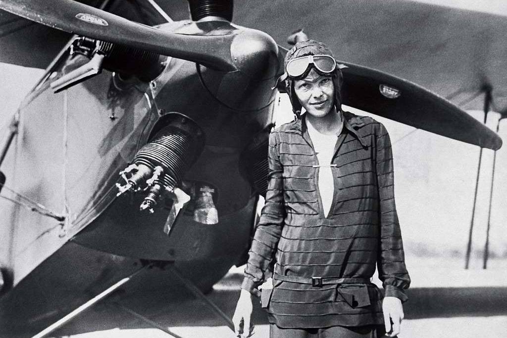 A photo of Amelia Earhart standing in front of an airplane