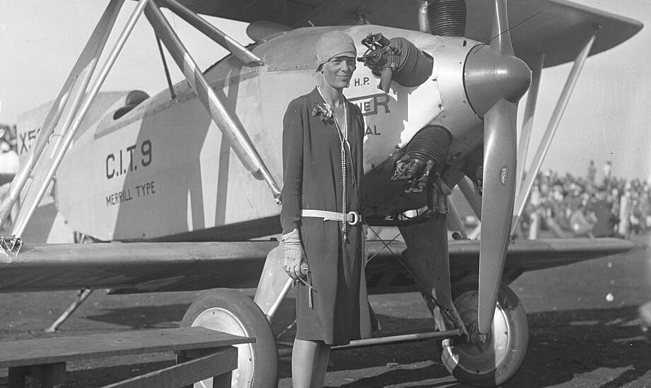 Amelia Earhart in front of an aircraft