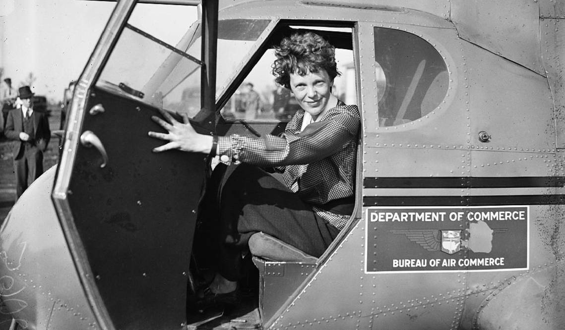 Amelia Earhart posing in an airplane