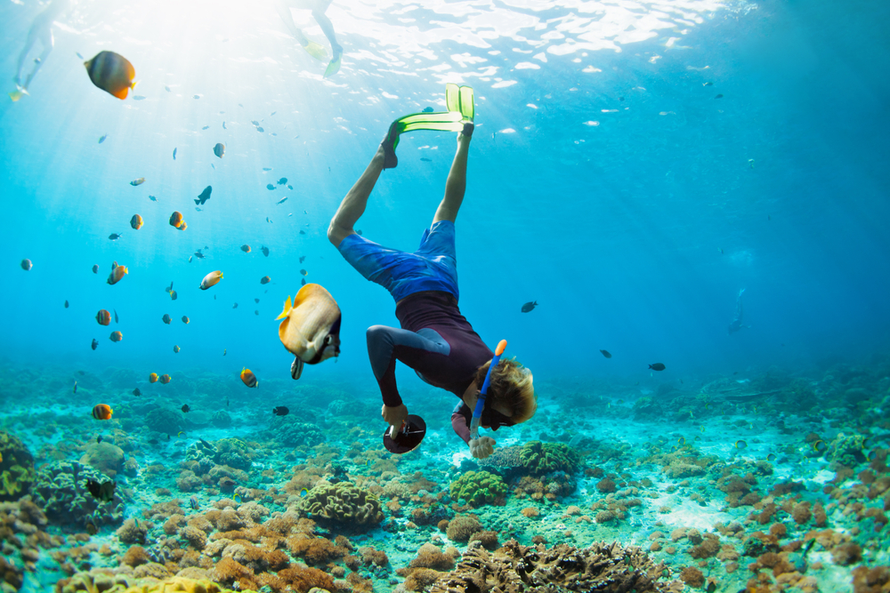 Man in snorkeling mask with camera dive underwater