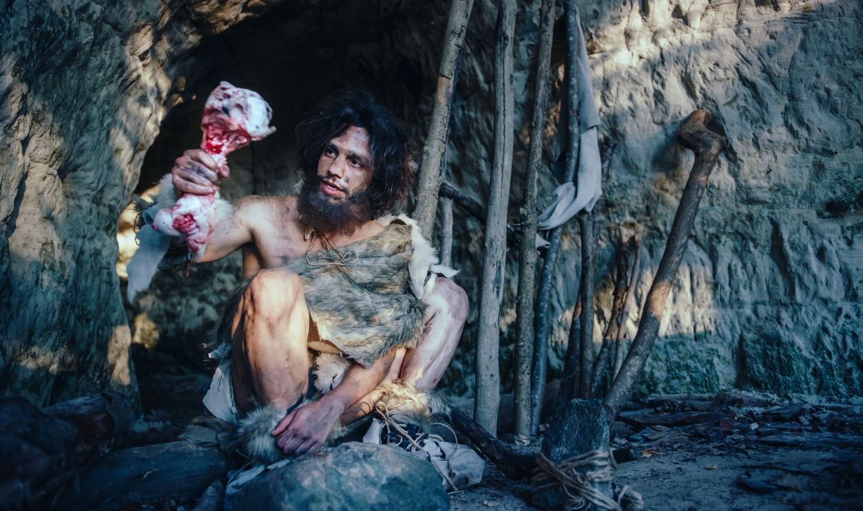 caveman eating meat
