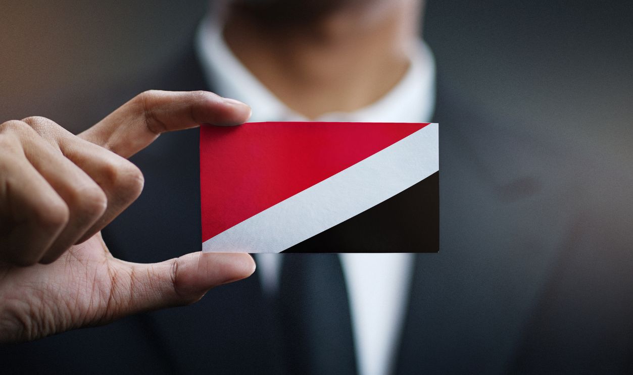 Businessman Holding Card of Principality of Sealand Flag