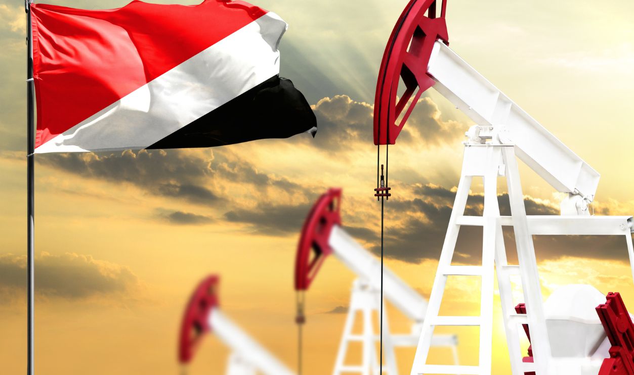 Oil rigs against the backdrop of the colorful sky and a flagpole with the flag of Sealand,