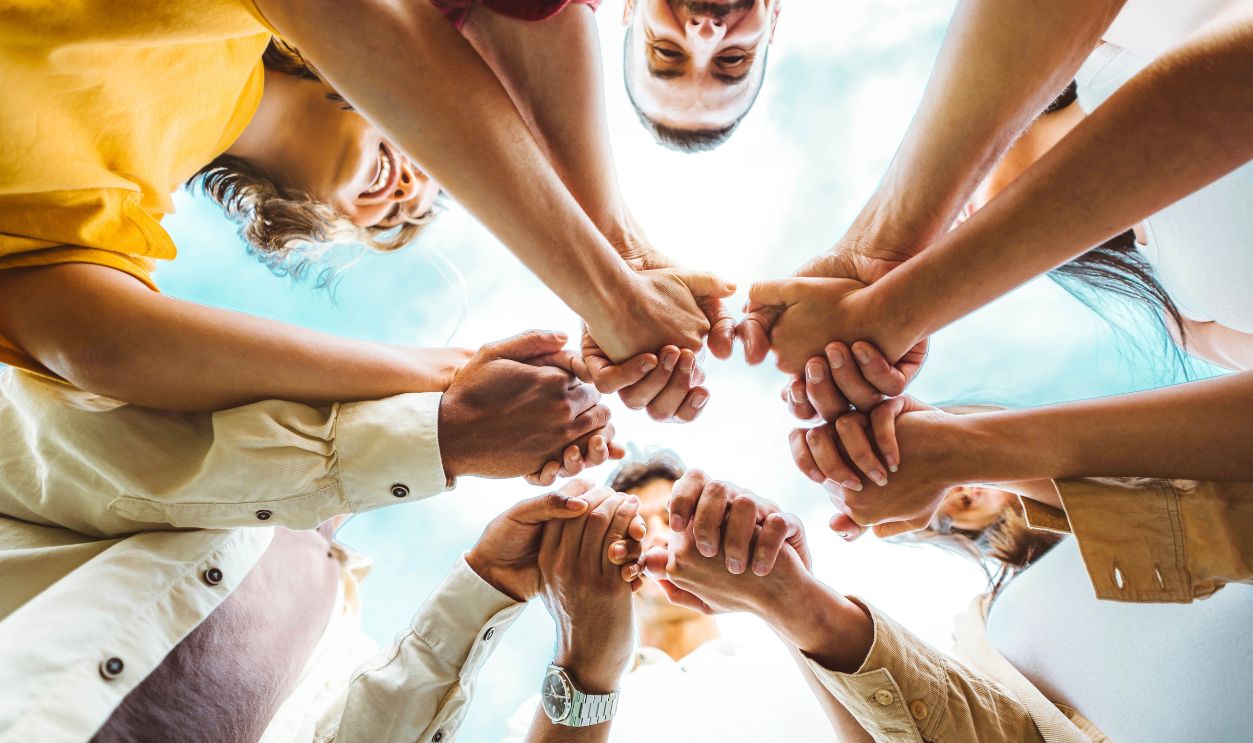 Multi ethnic group of young people holding hands