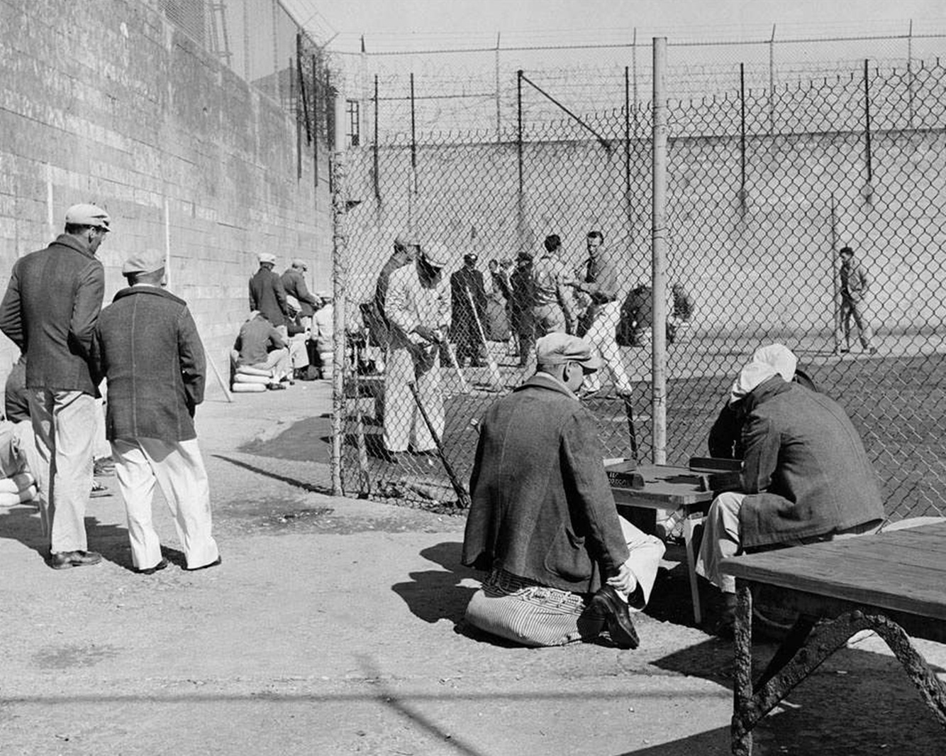 Alcatraz inmates playing dominoes and baseball in the recreation yard, c1935-1960.