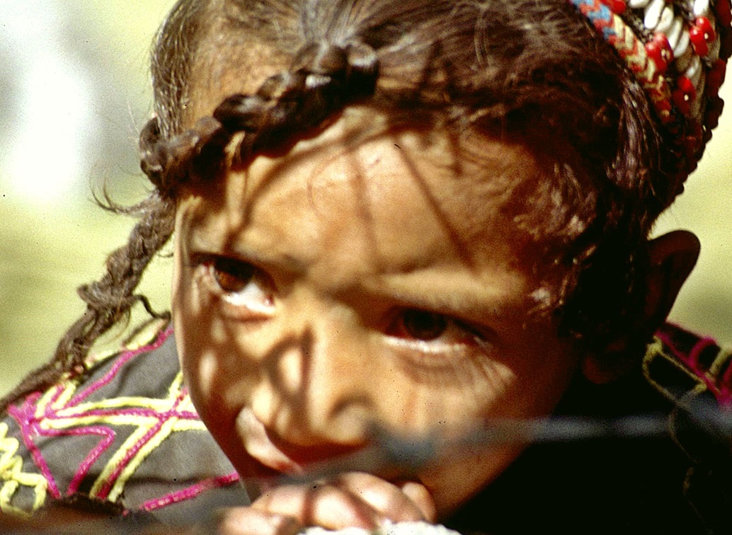 Kalash girl hiding outside.