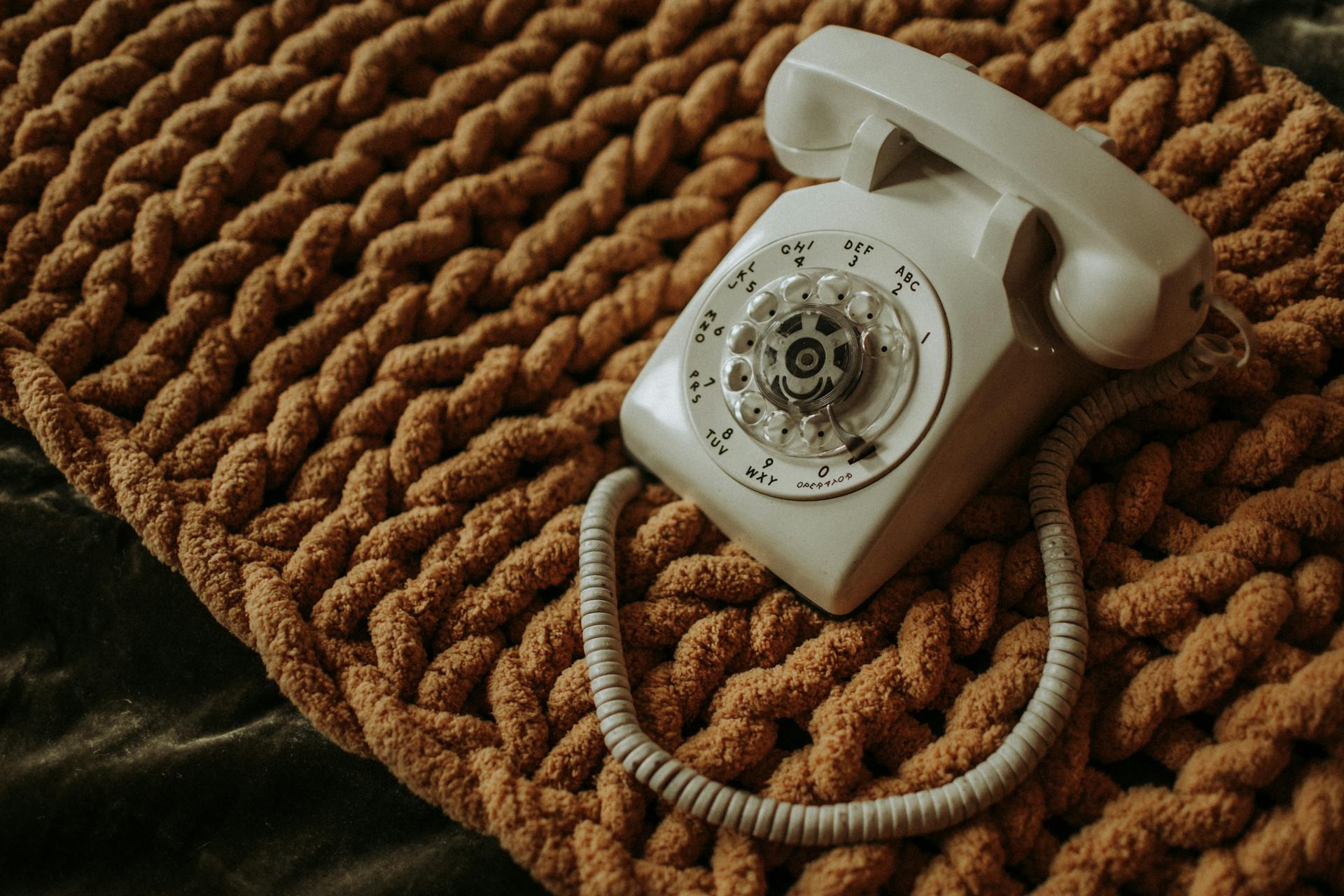 White Corded Telephone on Brown Textile