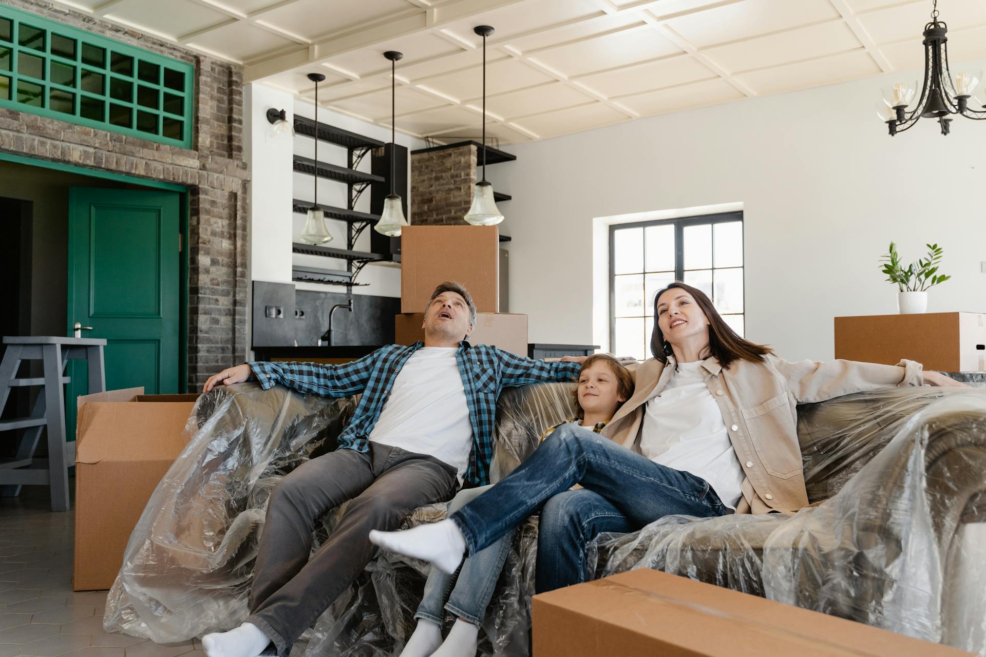 A Family Sitting on Couch Covered with Plastic