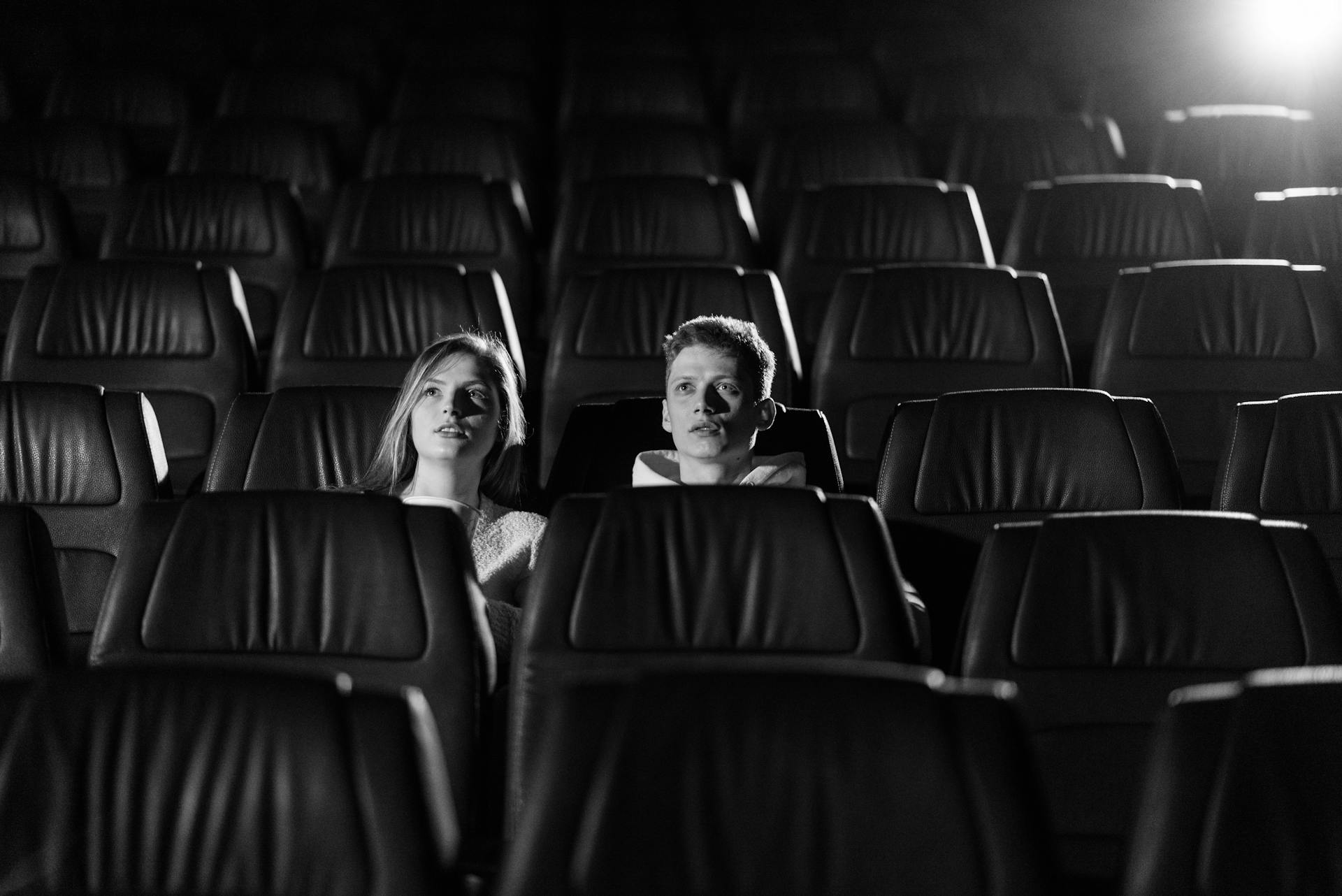 A Grayscale of a Couple Watching in a Cinema