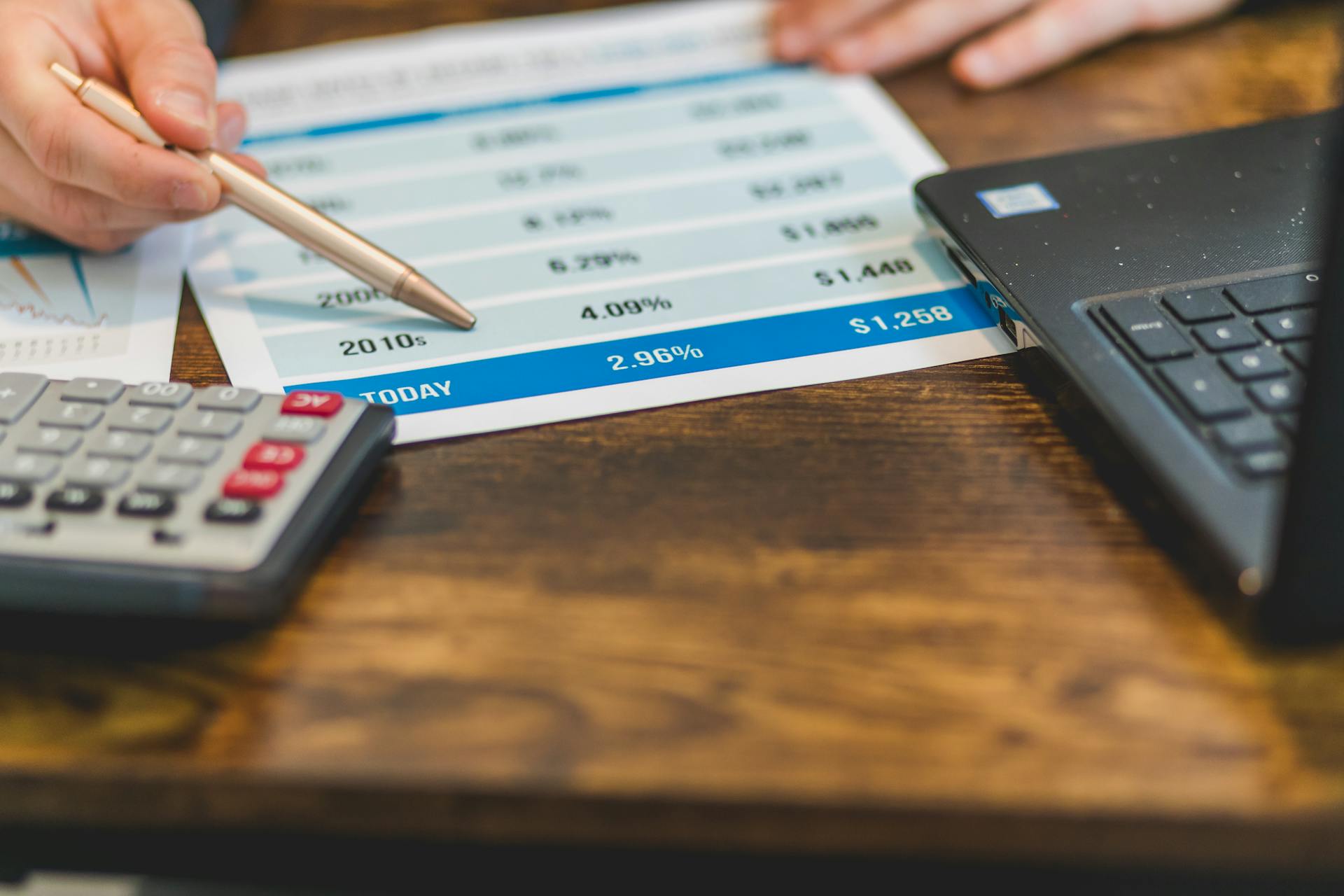 Close-Up Shot of an Agent Pointing Rates with a Ballpen