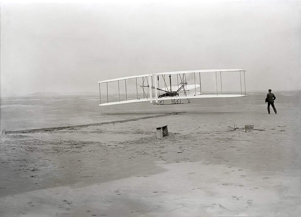 Grayscale Photo of The first powered, controlled, sustained airplane flight in history