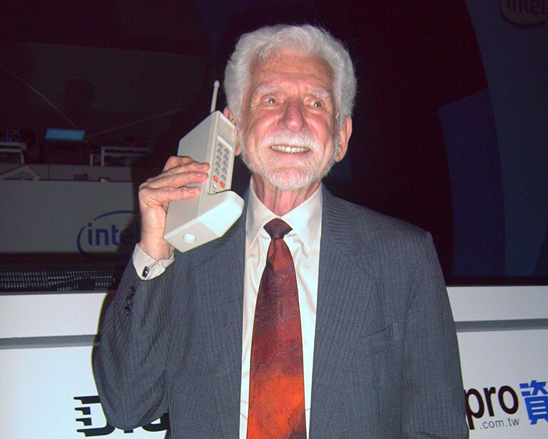 Portrait Photo of Dr. Martin Cooper with DynaTAC prototype from 1973