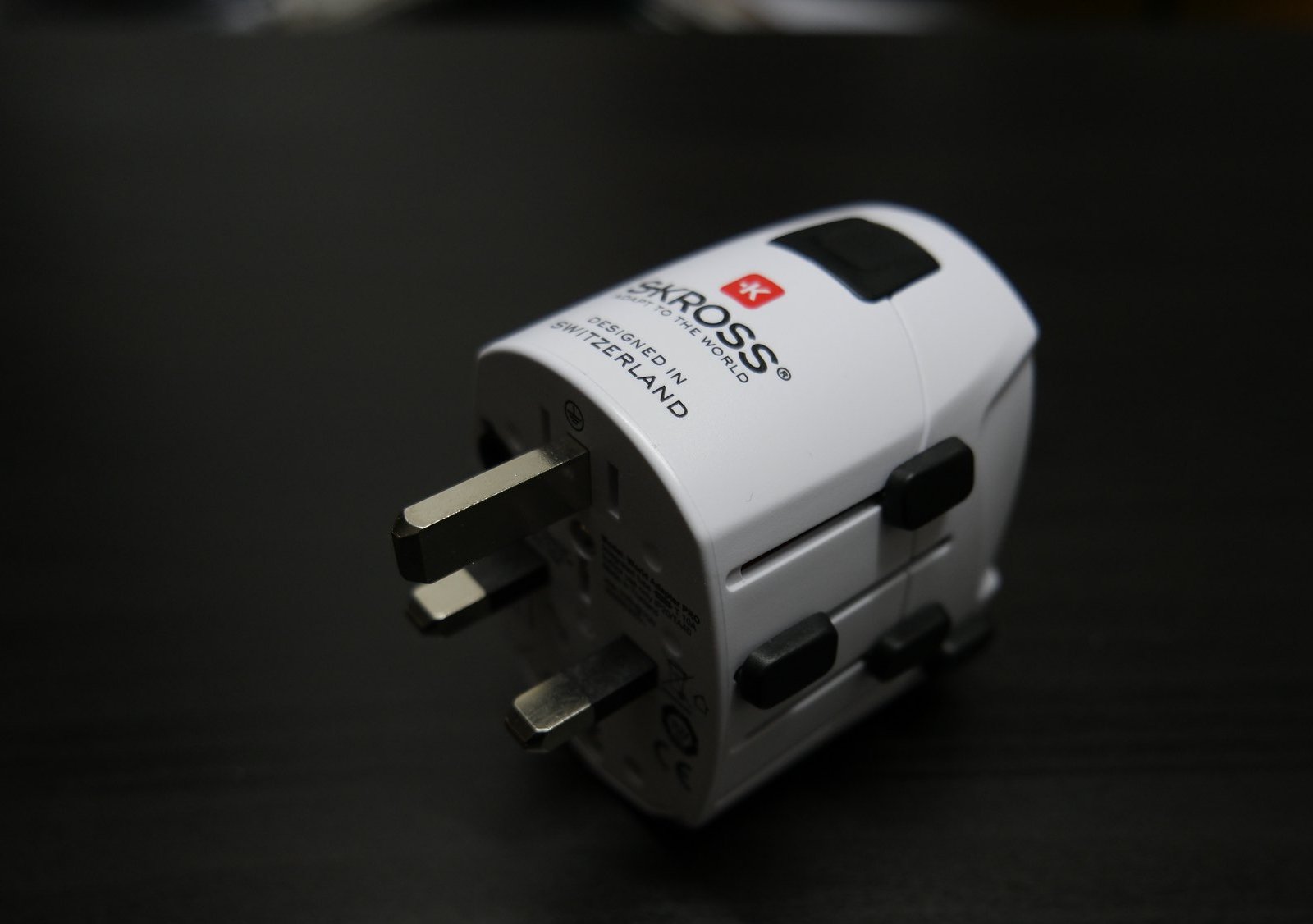 This image shows a Skross world travel adapter on Dark Background