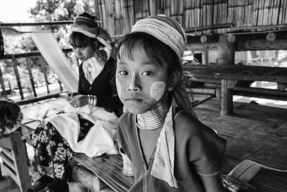 Karen Long Neck hill tribe village (Kayan Lahwi), young girl and her mother in traditional costumes