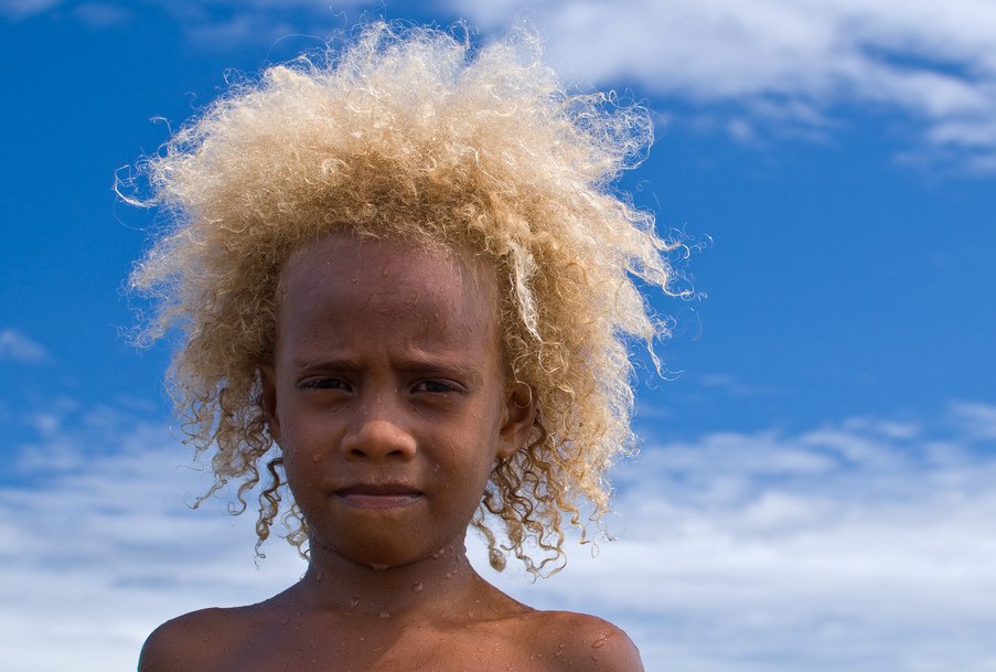This image shows a young child from Vanuatu with natural blonde hair
