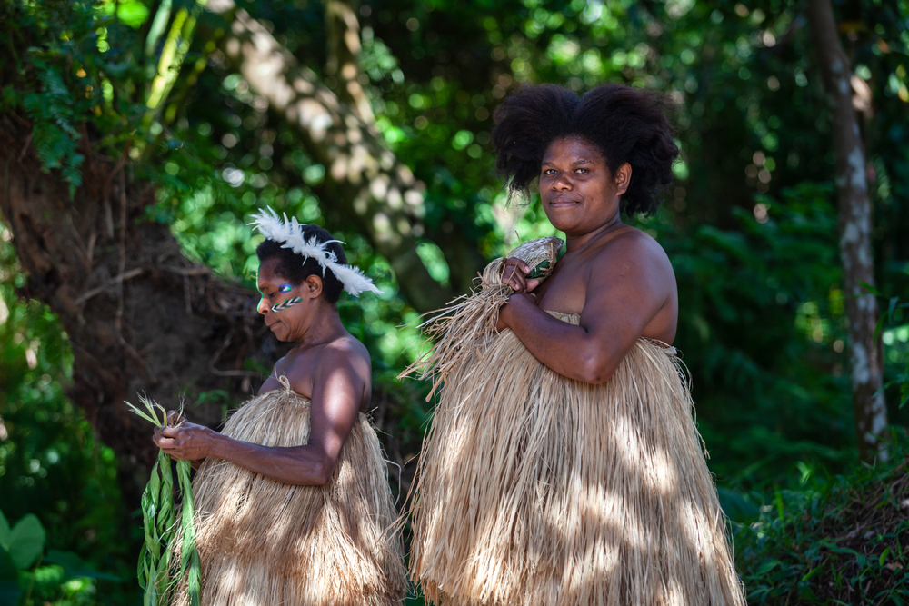 This image captures weaving Melanesian women in traditional indigenous dress