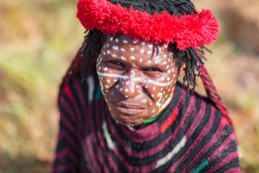 Portrait Photo of a young Dani woman, wearing white make up on the face