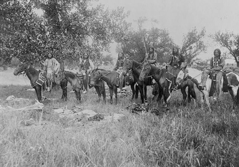 6 Indians on horseback, 3 holding up rifles