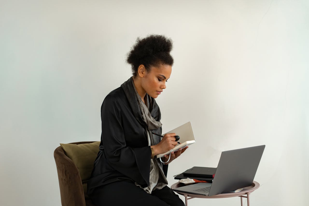 Woman in Black Jacket Writing on Notebook