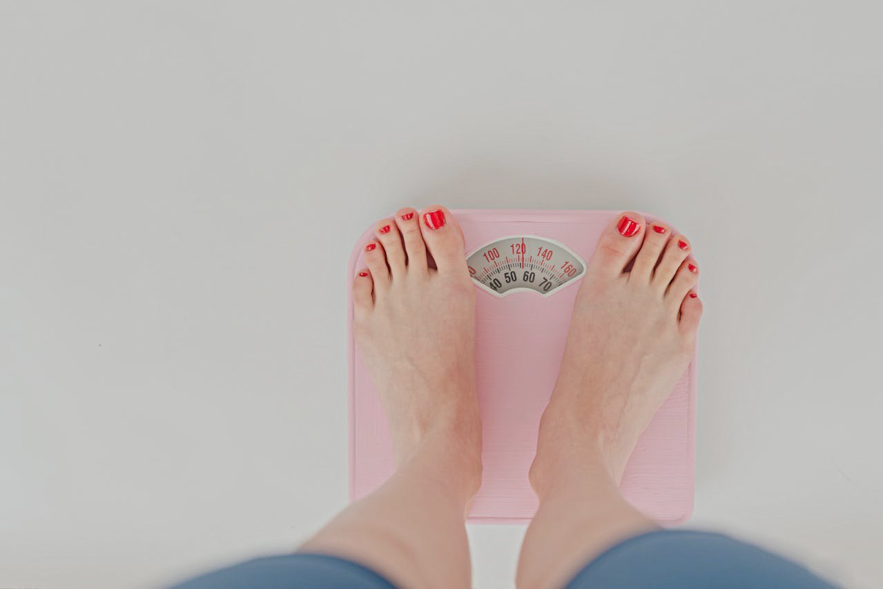 Woman weighing on scales in studio