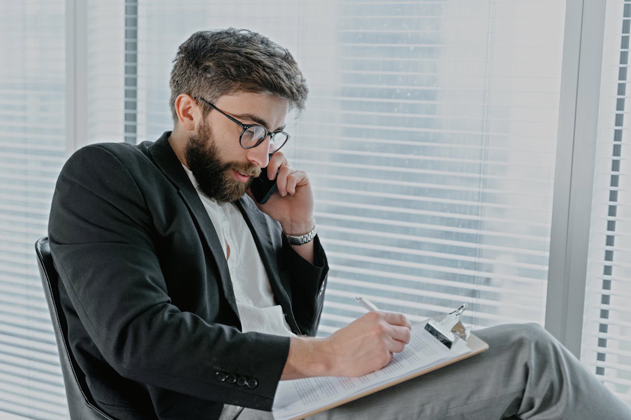 Man in a Black Jacket, Writing on Clipboard