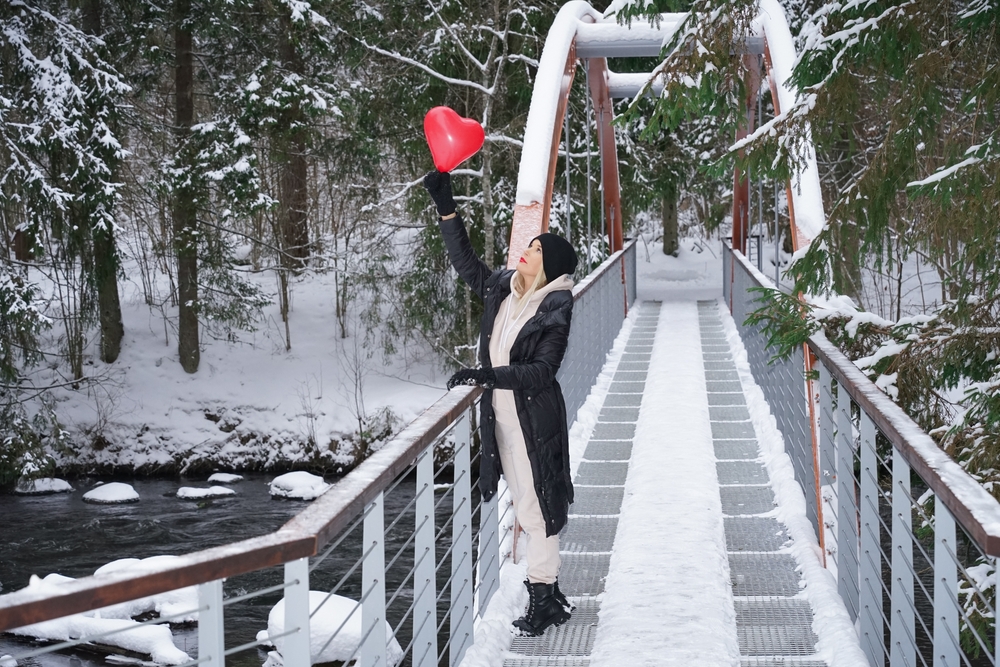 A girl with a red balloon in the form of a heart