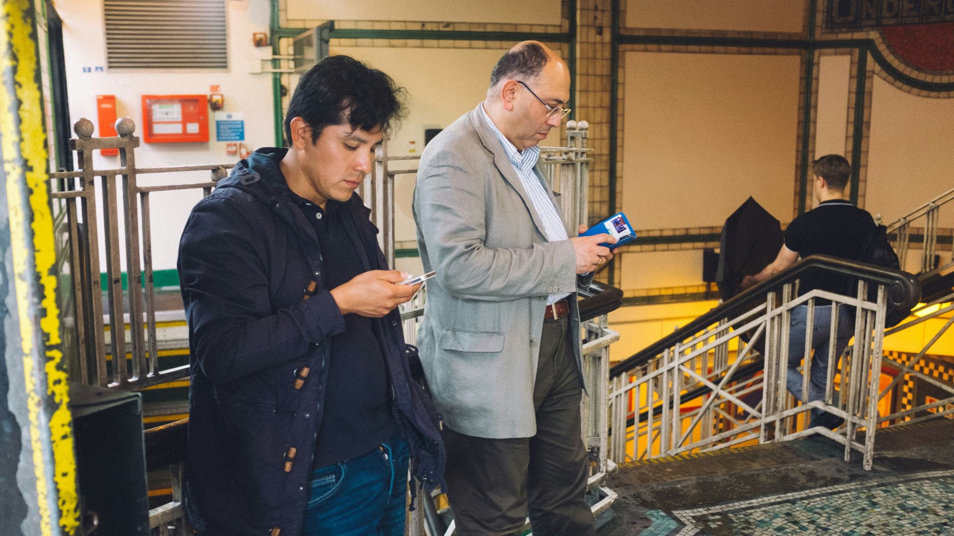 man in blue dress shirt standing beside man in gray dress shirt