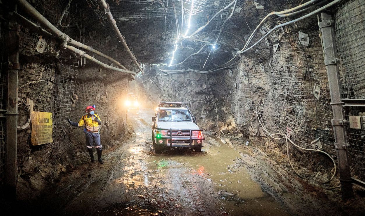 An employee from Gold Fields South Africa company stands next to an access vehicule at the South Deep gold mine in Westonaria, Gauteng, on October 12, 2022. 