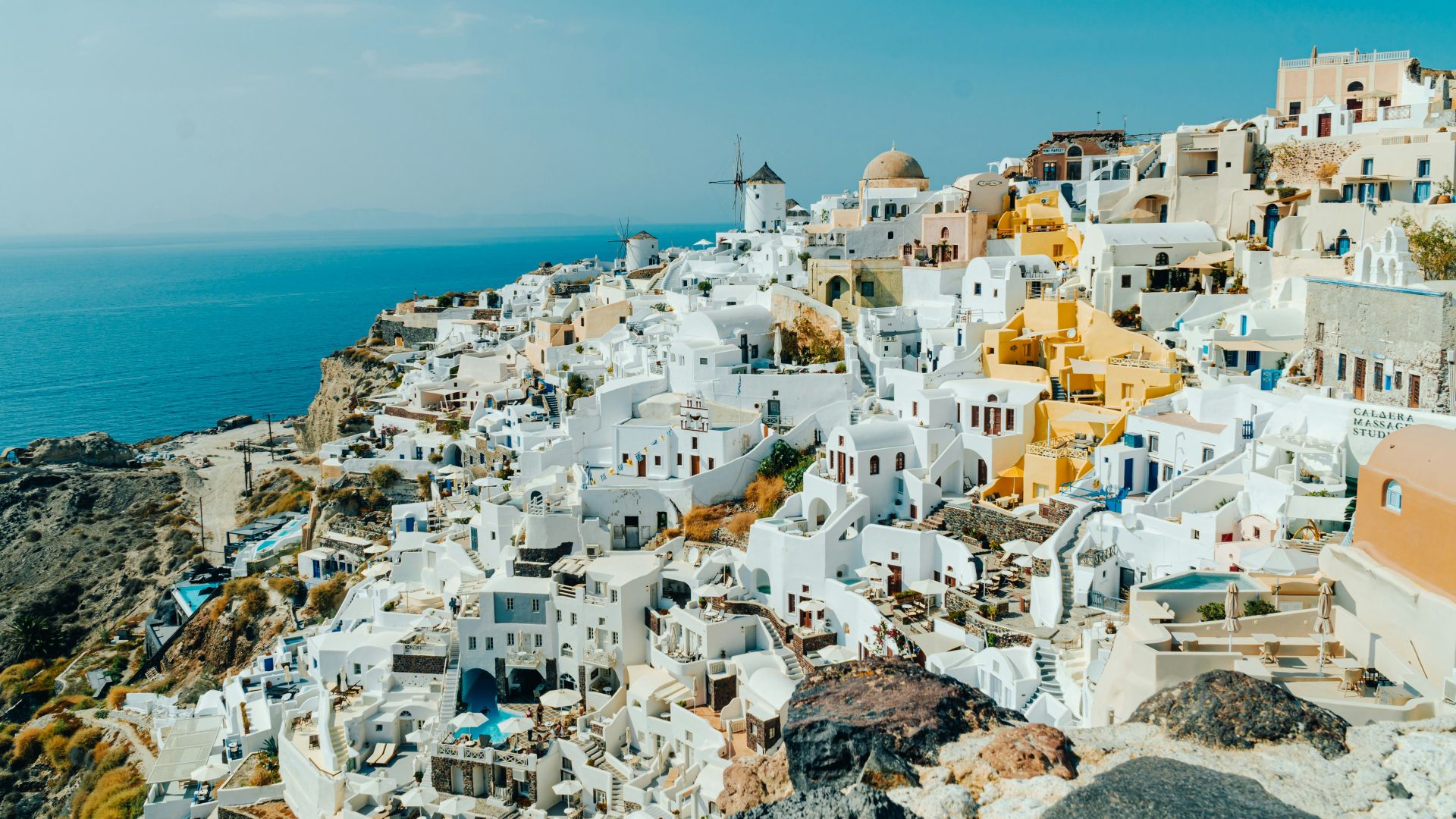 an aerial view of a village on a cliff overlooking the ocean