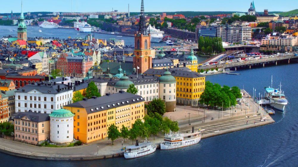 The image showcases a Vibrant urban scene of Stockholm, Sweden captured from a high vantage point. The city appears well-developed with a mix of modern and historic architecture.