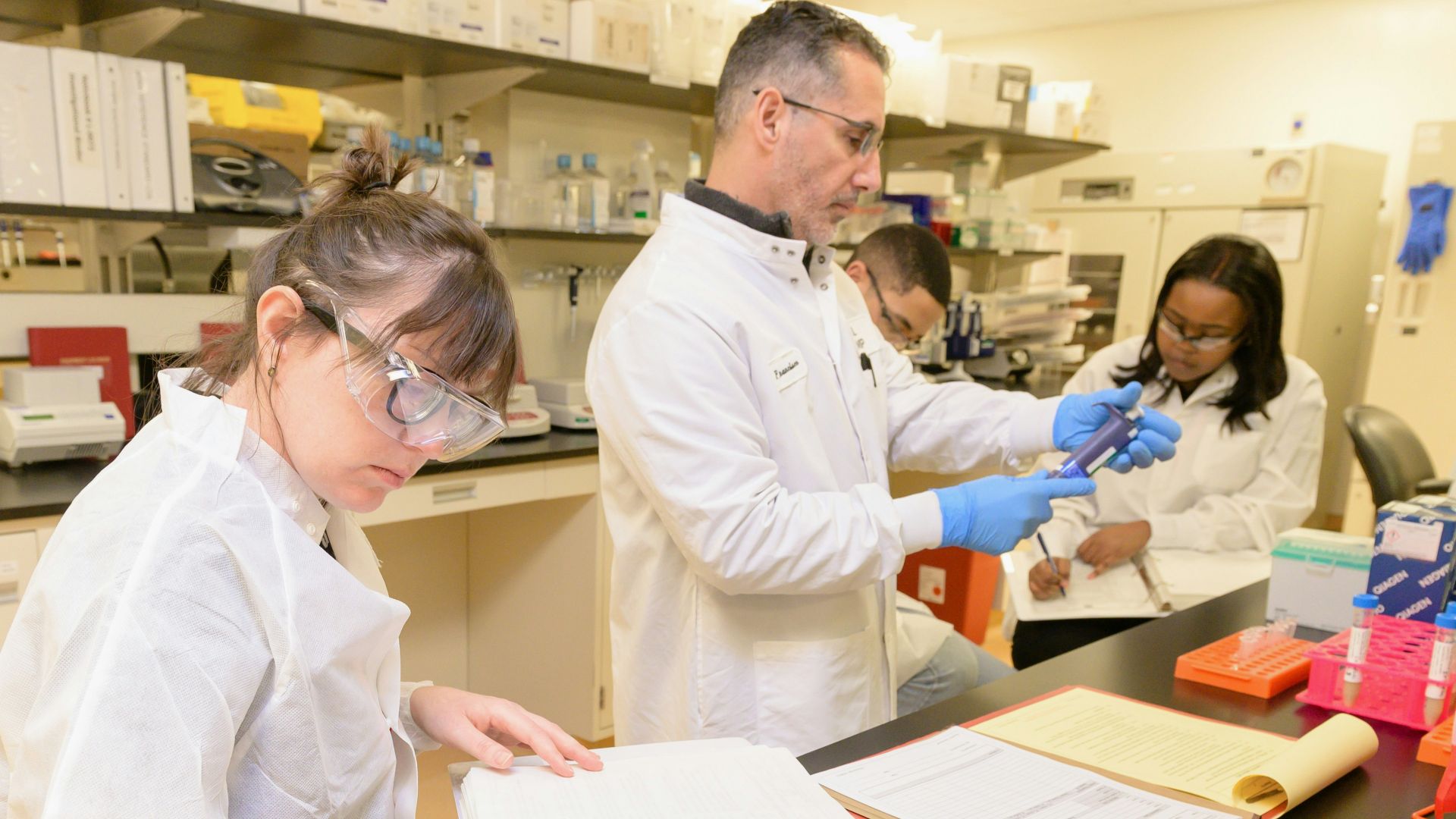 a group of people in lab coats working in a lab