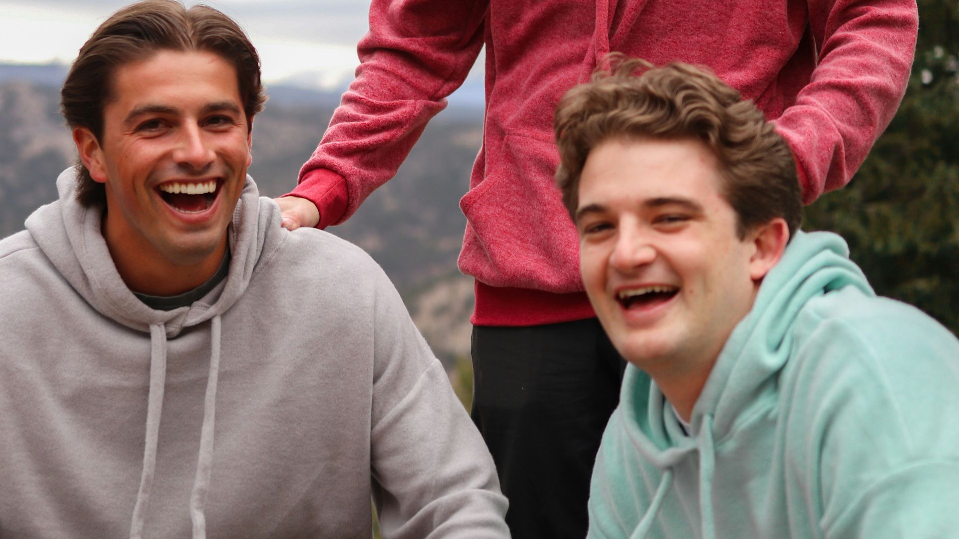 man in red hoodie beside woman in gray hoodie