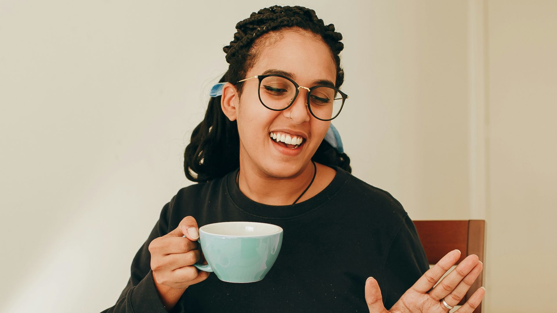 woman in black long sleeve shirt holding white ceramic mug