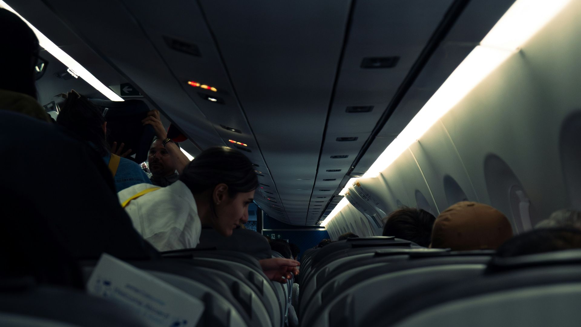 Passengers are seated inside an airplane.