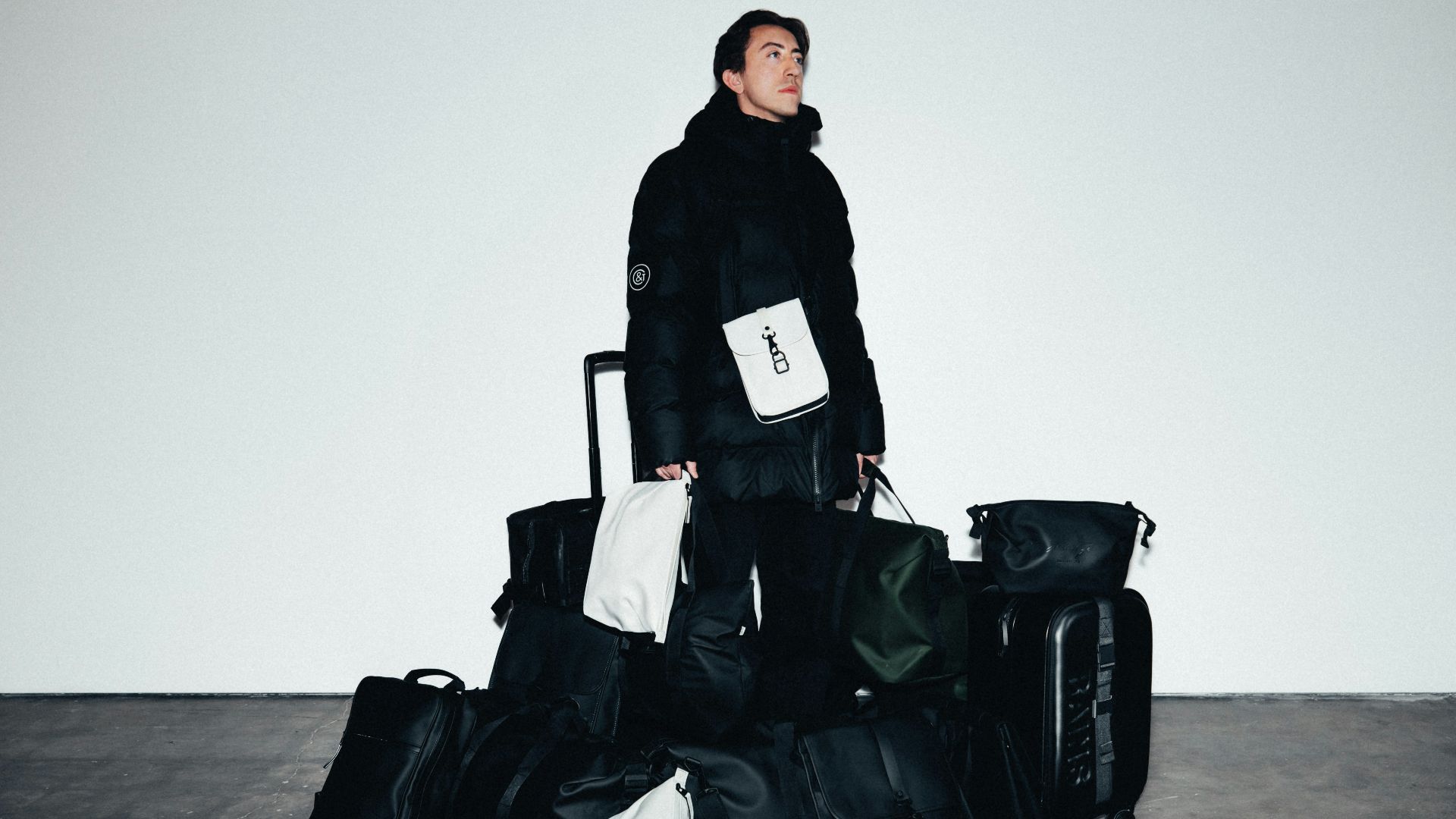 Man in winter coat surrounded by luggage