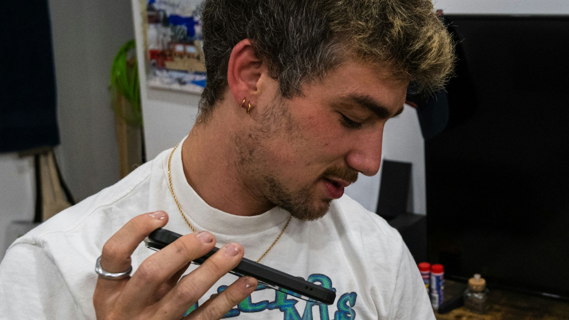 a man standing in front of a tv holding a cell phone