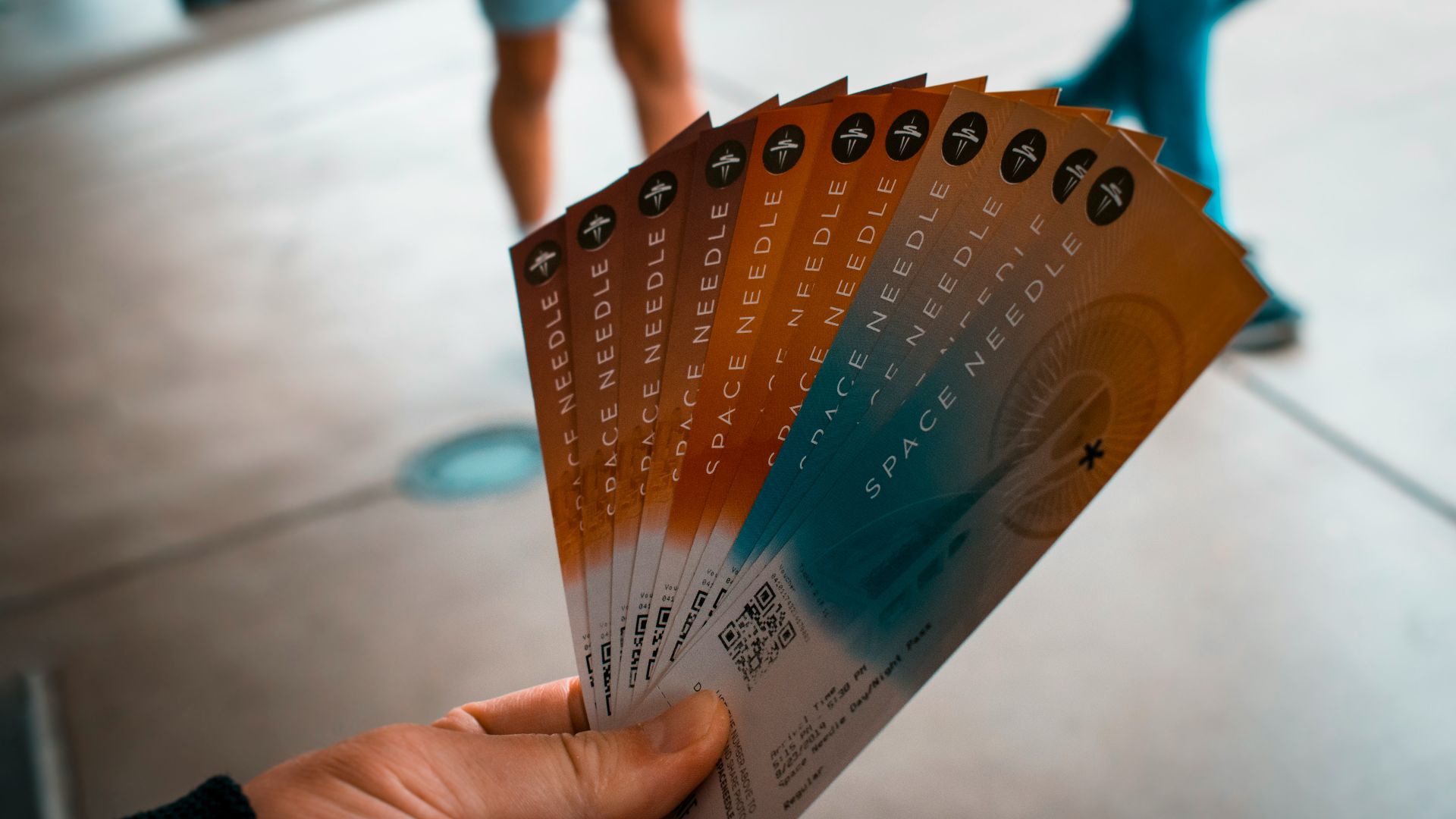 person holding brown, blue, and white tickets