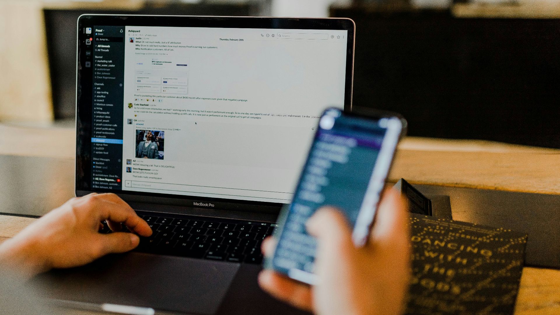 person using phone and laptop