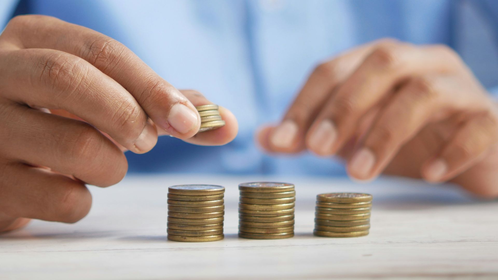 a person stacking coins on top of a table