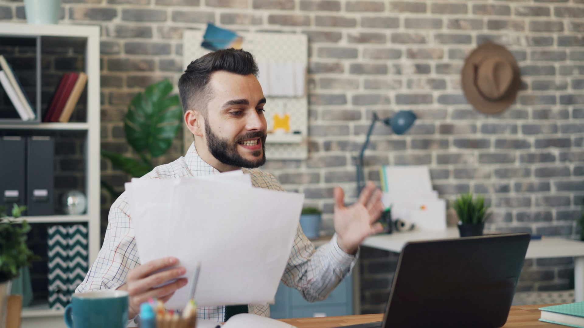 a man sitting at a desk with a laptop and papers