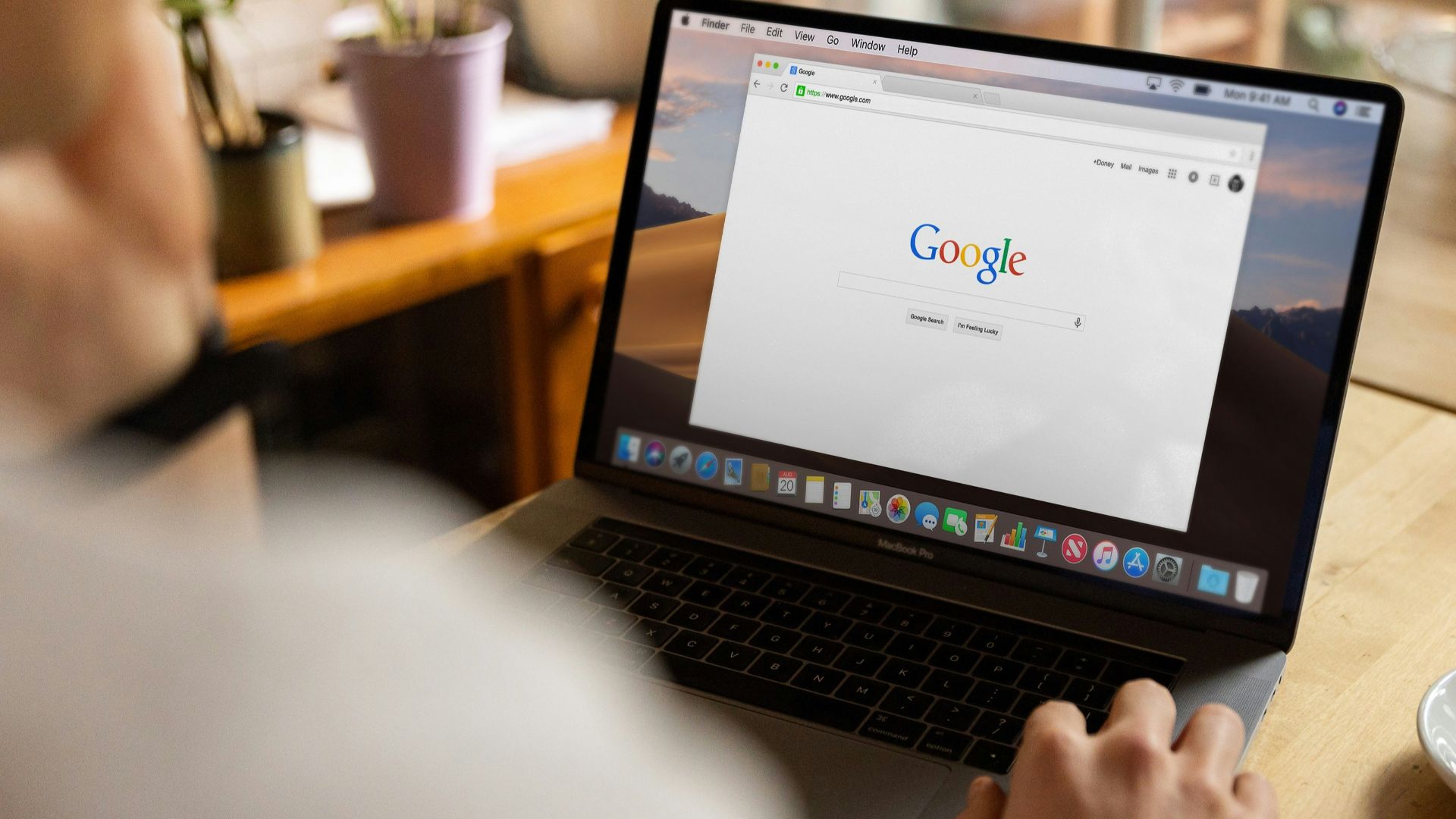 person using macbook pro on table