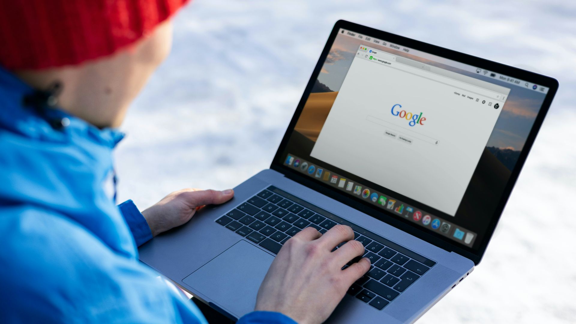 person in blue long sleeve shirt using macbook pro