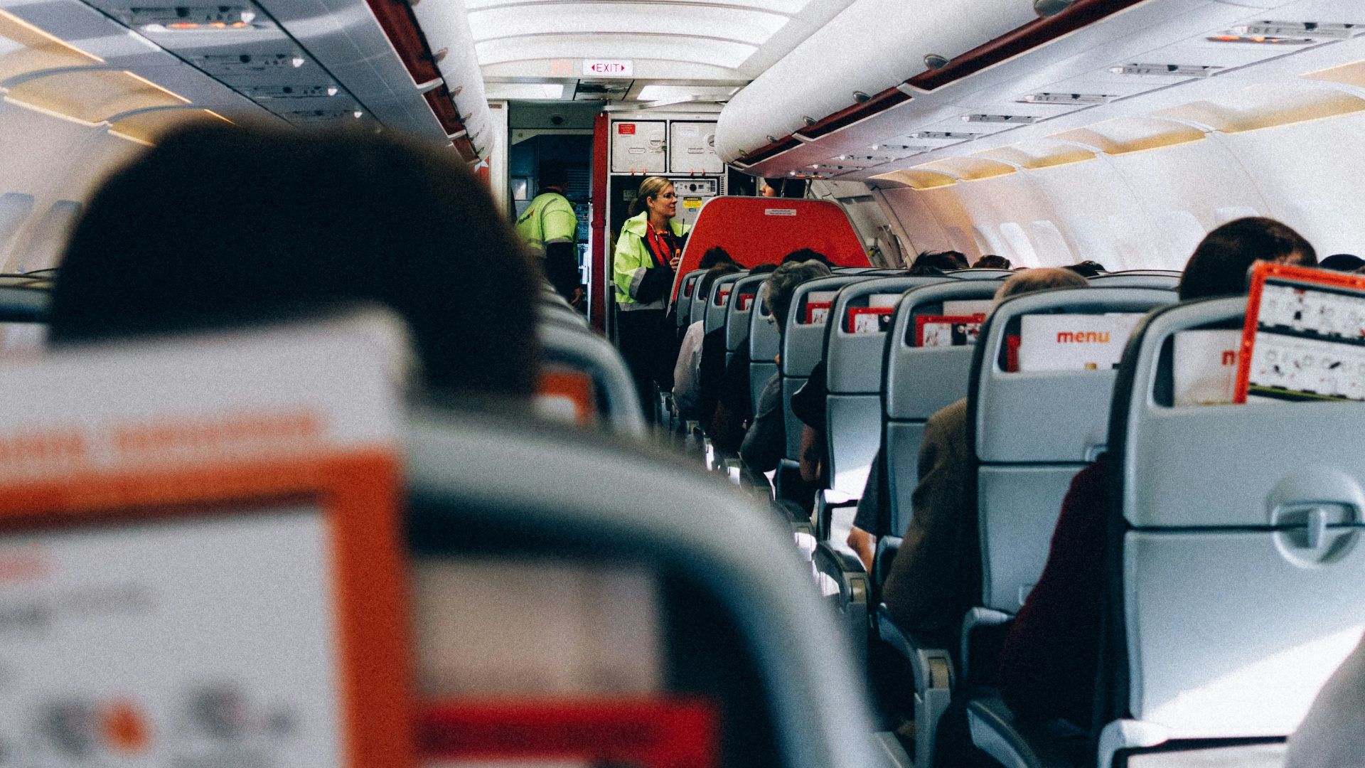 the inside of an airplane with people sitting on the seats