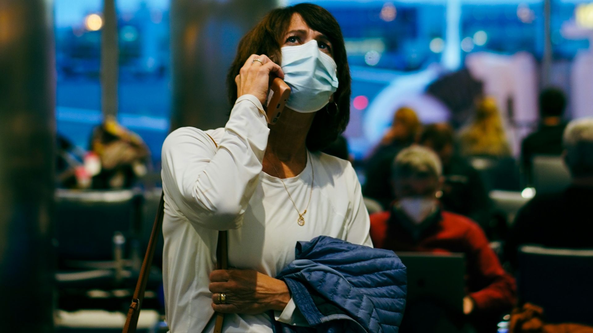a woman wearing a face mask at an airport