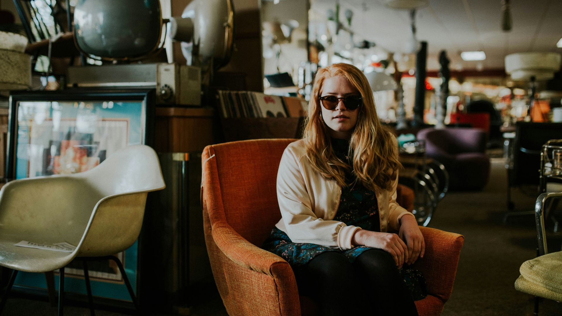 woman sitting on sofa wearing sunglasses