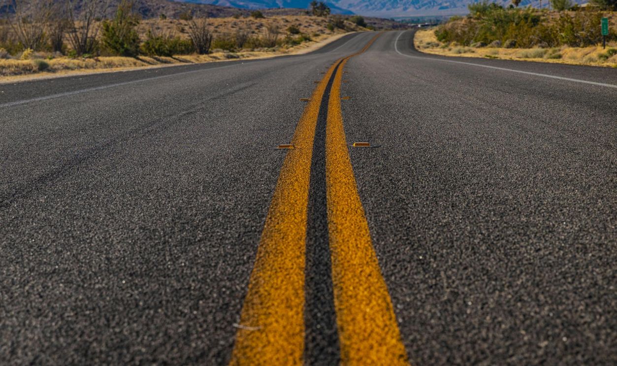 A Pair of Solid Yellow Markings on Asphalt Road