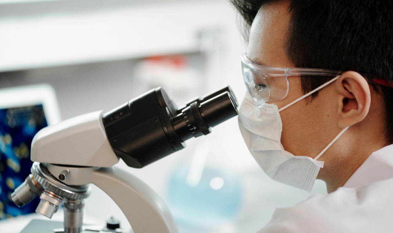 Man Looking Through A Microscope